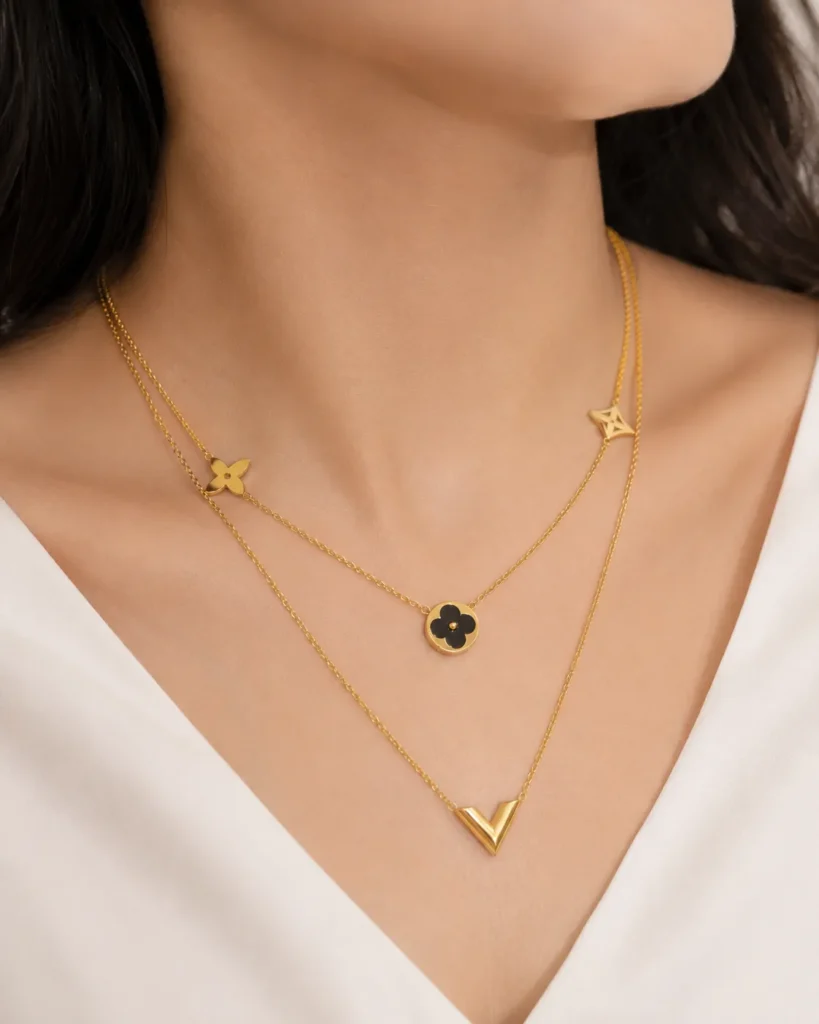Black Double Layered Charm Necklace featuring layered gold chains with a black floral charm and V-shaped pendant