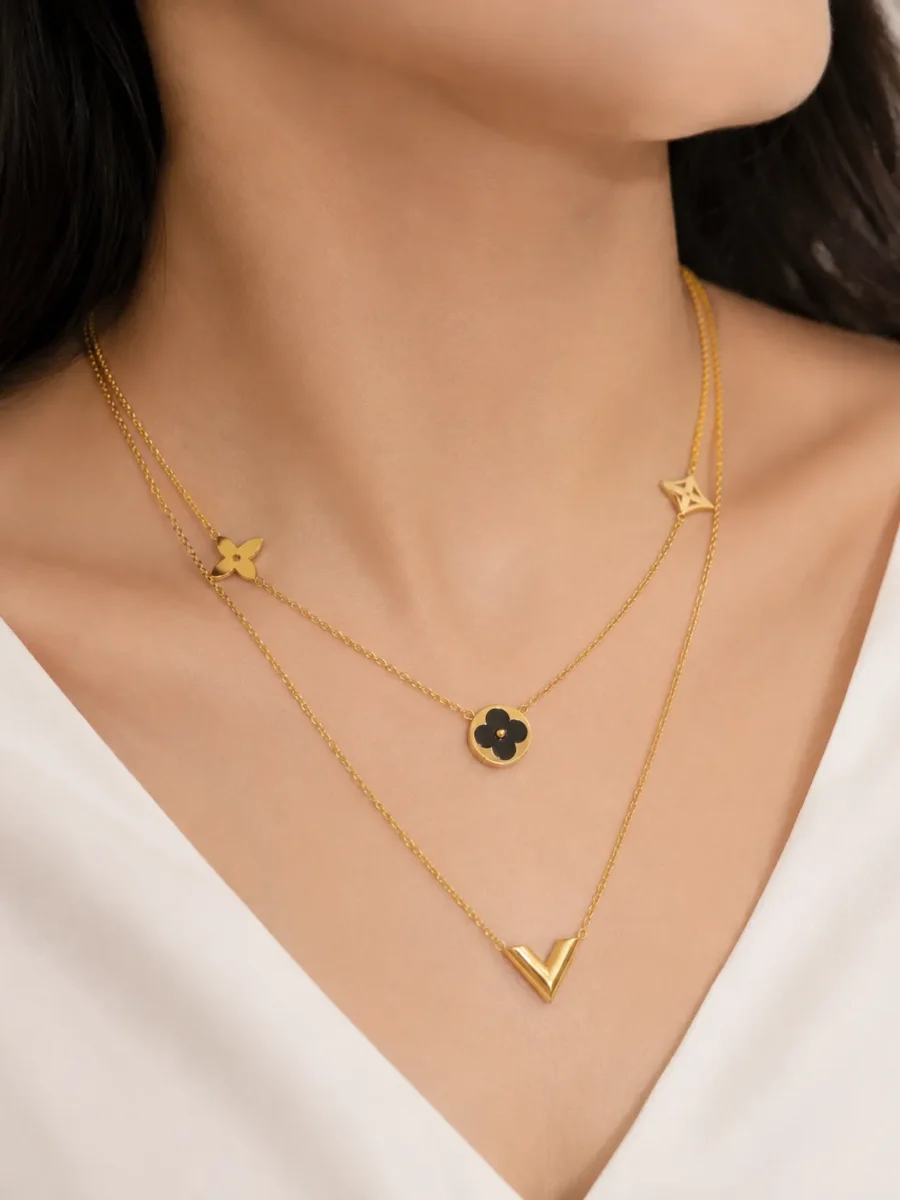 Black Double Layered Charm Necklace featuring layered gold chains with a black floral charm and V-shaped pendant