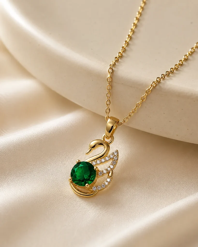 Emerald Swan Pendant Necklace featuring a green crystal and sparkling zirconia accents in a premium gold finish
