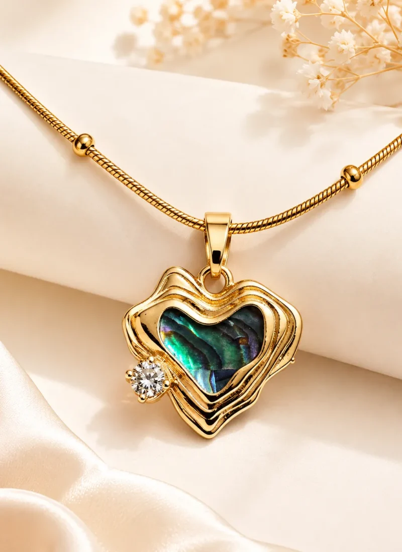 Heart of Sea Necklace featuring an iridescent ocean-inspired heart stone with a sparkling crystal accent in a premium gold finish