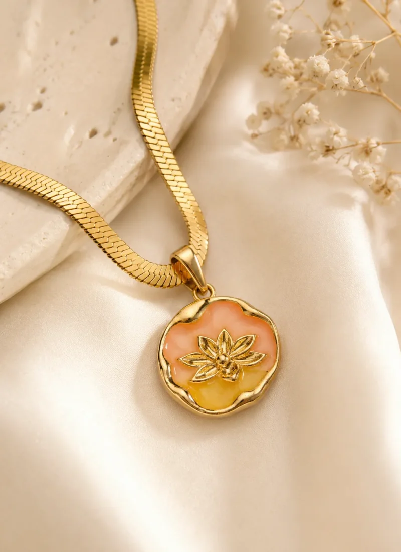 Peach Blossom Necklace featuring a peach and golden floral enamel pendant with a premium gold finish