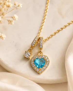 Blue Crystal Heart Pendant Necklace featuring a sparkling blue heart crystal with pavé stones in a premium gold finish
